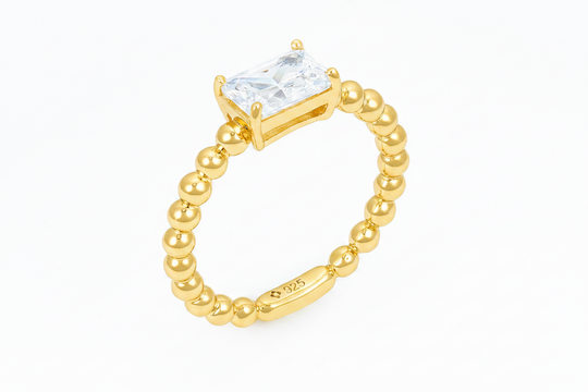 Emerald cut solitaire ring with beaded shank in Gold