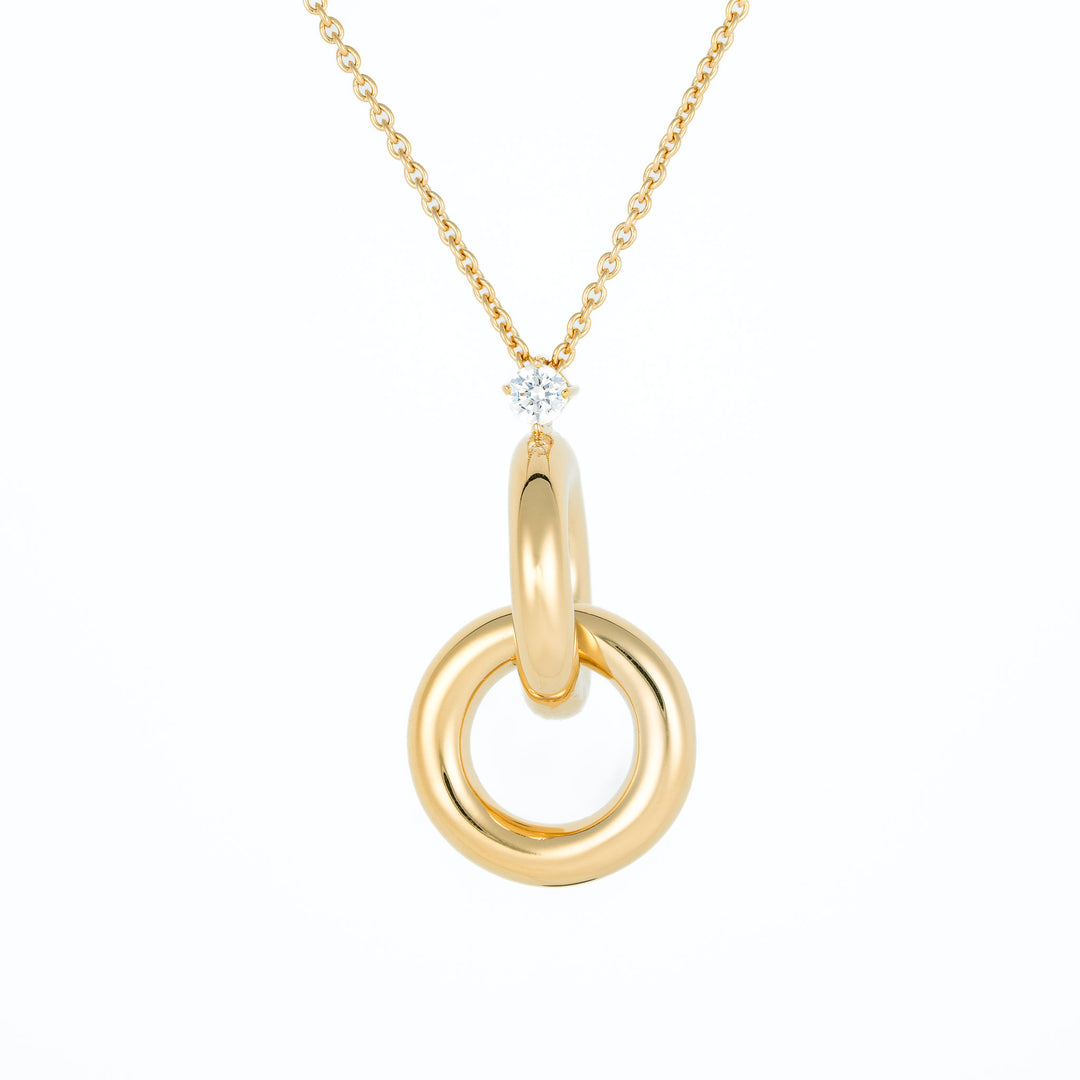 Gold necklace with a double circles pendant on a white background
