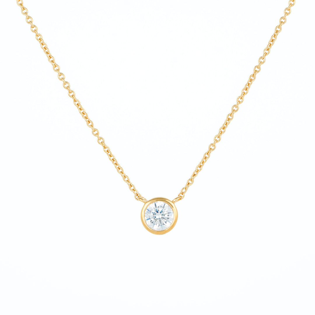 Solitaire pendant necklace with bezel set round stone in gold